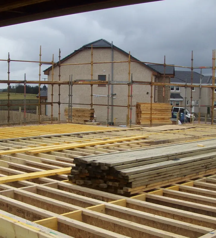 First floor joists in place, with a neighbouring home under scaffold
