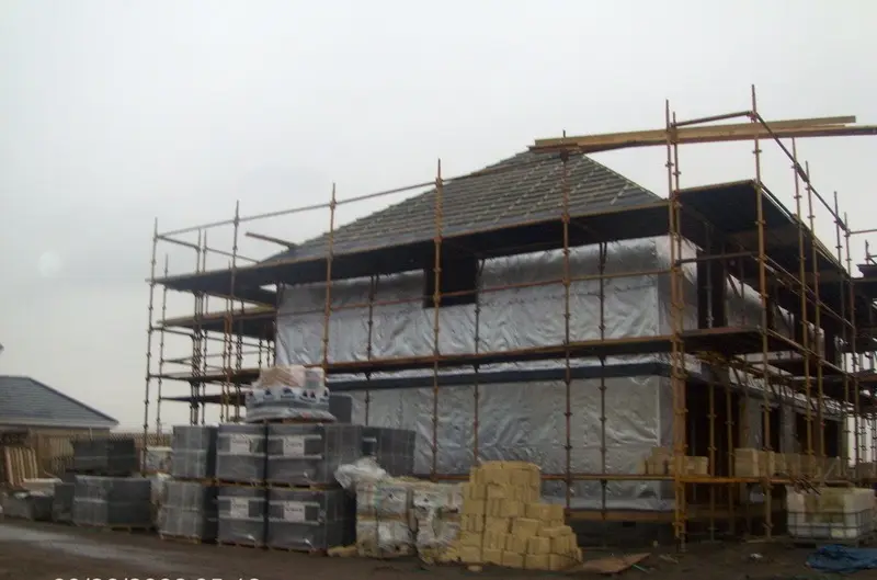Roof tiled and walls wrapped in breather membrane