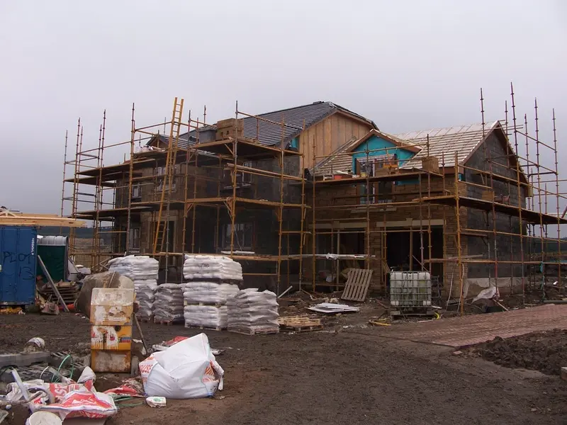 Two of the homes under scaffold as the stone cladding goes on
