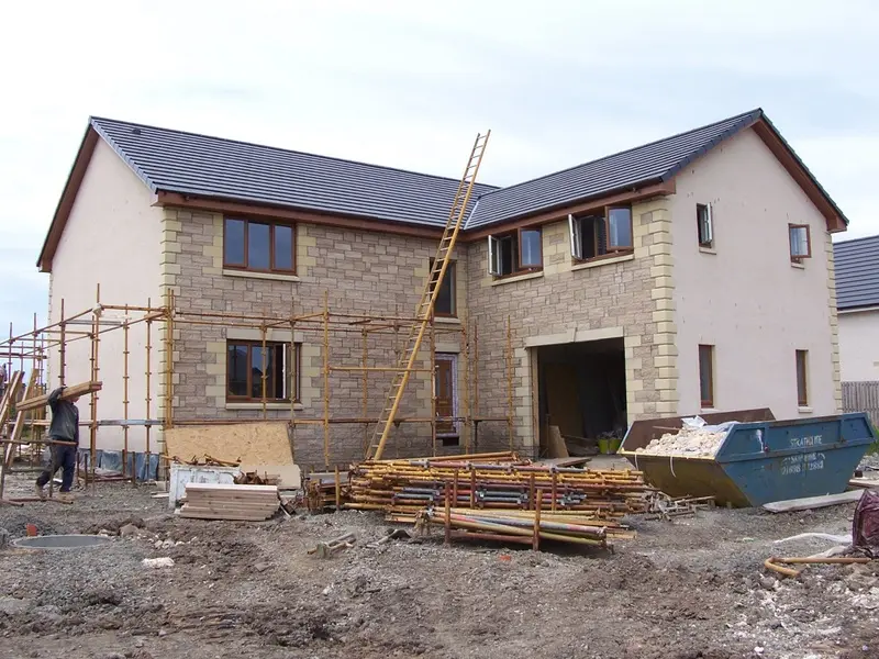 Stone and render home nearing completion under scaffold
