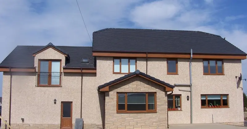 Finished rear elevation with a stone-faced bay and Juliet balcony