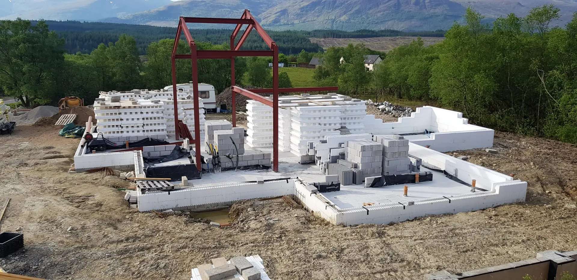 Steel portal frames standing on the slab, with ICF blocks stacked ready