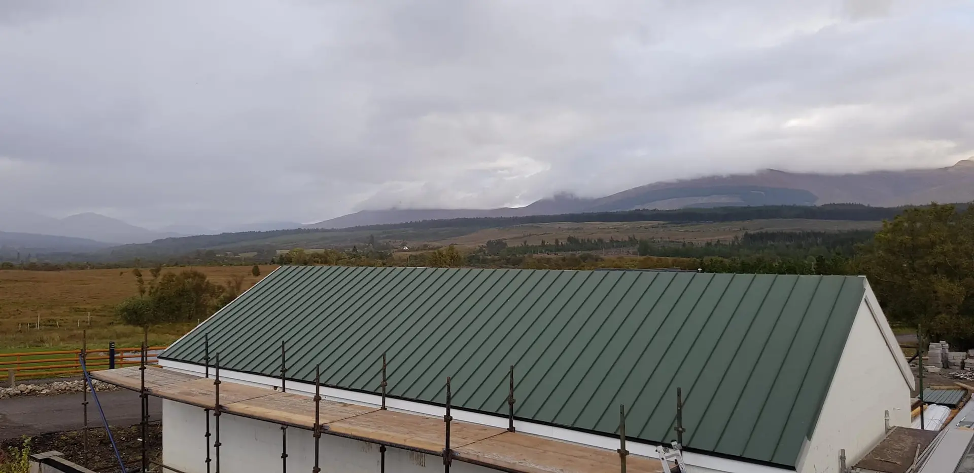 Standing-seam metal roof complete, with the mountains beyond