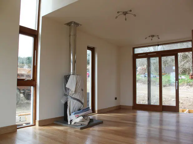 Sasaig living room with wood burner, oak floor and glazed doors to the garden