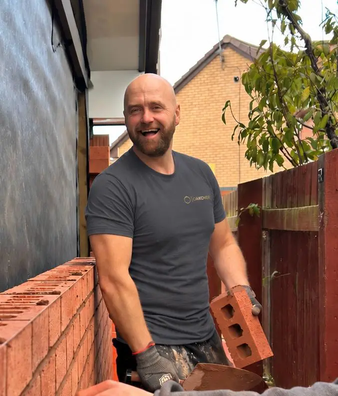 Steven Duncan, Co-Founder of Oakover Developments, laying bricks on site in an Oakover t-shirt